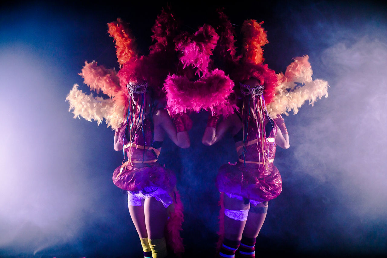 Cabaret dancers dressed in feathers during the Three Cruise Production Show